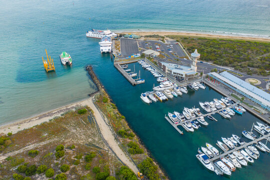 Aerial view of boats and yachts anchored along jettys at a marina
