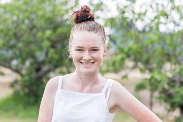 Teenage girl standing in yard at home smiling happy