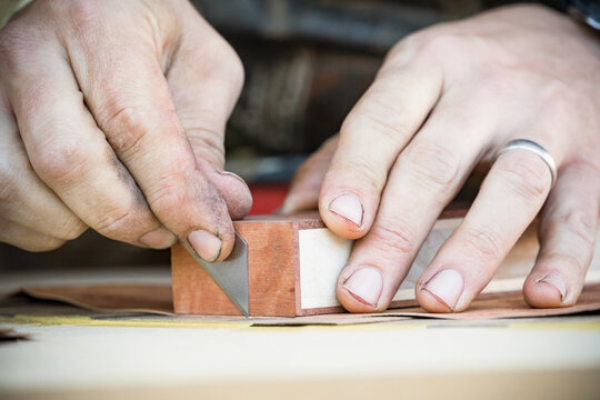 Close up of a tradesman's hands with with a sharp blade
