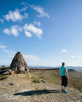A woman in hiking gear overlooking the rugged landscape of the Flinders Ranges