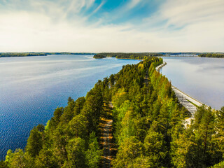 Aerial picture of the road between trees in Punkaharju, Lake Saimaa, Savonlinna Finland. Network of waters and islands, which are connected by narrow straits creating unique lakeland labyrinth.