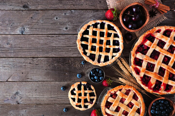 Variety of homemade fruit pies. Top down view over a dark wood background with copy space. Cherry,...