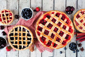 Selection of homemade fruit pies. Above view table scene over a rustic white wood background. Autumn food concept.