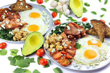 Fried eggs and bacon with a serve of spinach mushrooms and toast