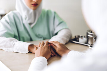Muslim asian woman doctor service help support discussing and consulting talk to muslim woman patient and holding hands at meeting health medical care express trust concept in hospital.healthcare 