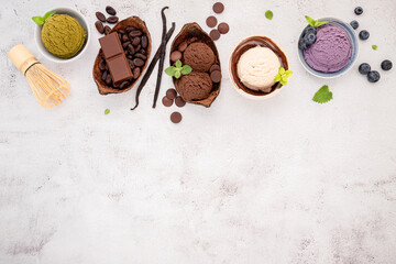 Various of ice cream  flavours in bowl blueberry ,green tea ,coconut  and chocolate  setup on white stone background .