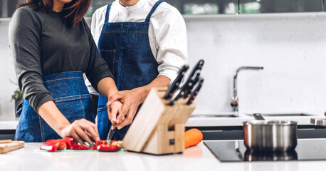 Couple having fun cooking together with fresh vegetable salad on table.Happy couple looking to prepare the yummy eating lunch in kitchen