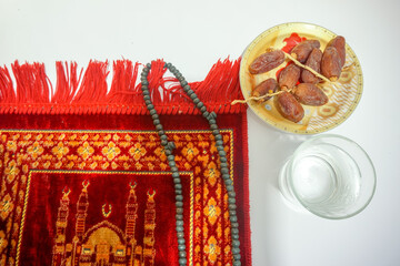 Dried dates fruits and prayer beads on the praying mats. Ramadhan kareem concept 