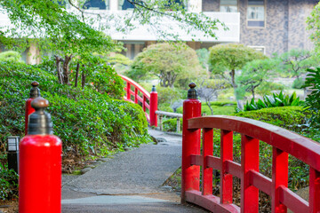 scenery of red colored traditional bridge and japanese garden in tokyo, japan