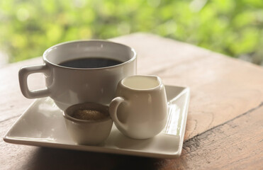 white ceramic cup of coffee on table with blurred background