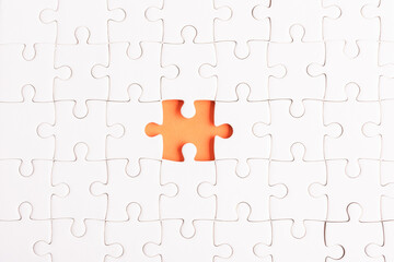 Top view flat lay of paper plain white jigsaw puzzle game texture incomplete or missing piece, studio shot on an orange background, quiz calculation concept