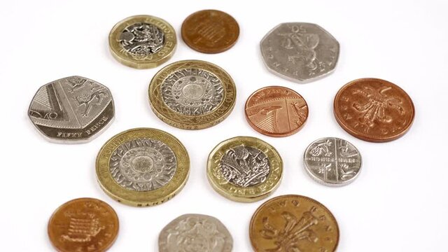UK Currency pounds coins rotating close up footage against the white background