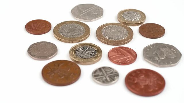 UK Currency pounds coins rotating close up footage against the white background