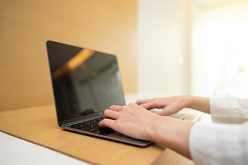 Woman working on laptop computer on wooden table. for your advertising text message.