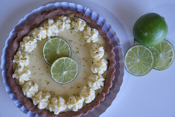 key lime pie. lime pie and whipped cream with sablé dough and garnished with slices and lime zest