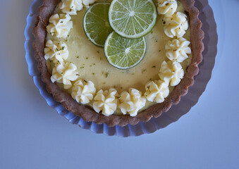 key lime pie. lime pie and whipped cream with sablé dough and garnished with slices and lime zest