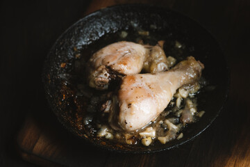 Roasted chicken with onion and garlic in pan