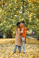 Cute couple in a park. Family in autumn clothes. Man in a brown sweater.
