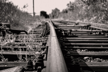 Old rusty rails. Abandoned industrial railway line with abandoned cars and trains. Blurred background.