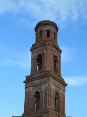 Fototapeta na wymiar Tower of an old abandoned Church against a blue sky with clouds