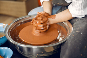 Girl make a vase. Pottery theme. On a pottery's machine.