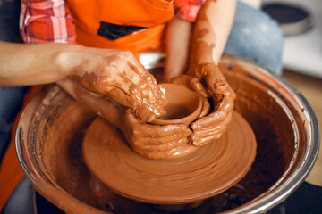 Girl make a vase. Pottery theme. On a pottery's machine. Little child on a master class.