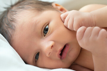 Close-up portrait of a newborn baby with open eyes.