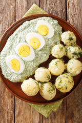 German cuisine boiled potatoes with eggs frankfurt green sauce close-up in a plate. Vertical top view from above