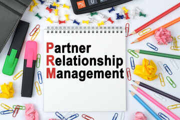 On the table is a calculator, diary, markers, pencils and a notebook with the inscription - PRM