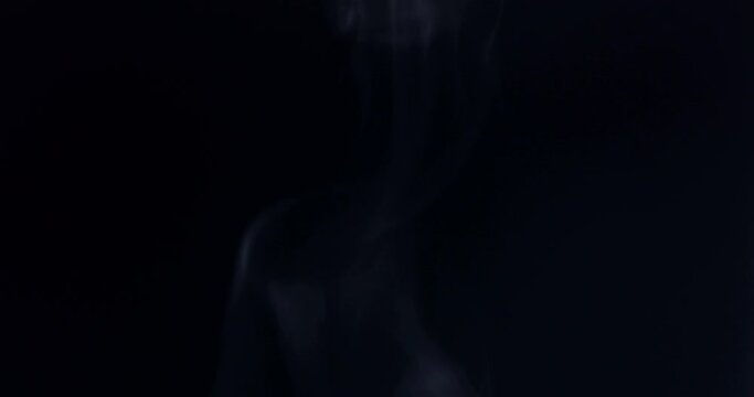 Smoke floating through space against black background