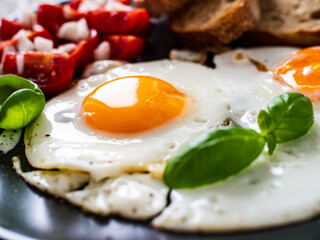 Continental breakfast - sunny side up eggs, toasts and vegetable salad
