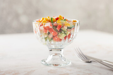 Salad of crab sticks, cucumbers, eggs and corn. Russian festive food