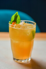 Iced lemon drink with mint on wooden table, indoors. Refreshing summer beverage on a table, alcohol cocktail