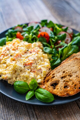 Vegetable mayonnaise salad with toasts on wooden table
