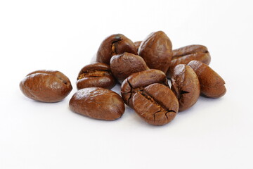 Roasted coffee beans close-up on a white background.