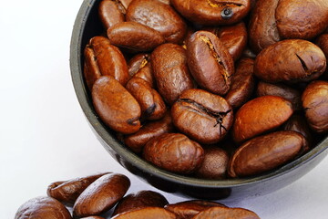 Roasted coffee beans close-up on a white background.