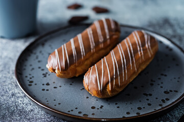Fresh eclairs on a plate with chocolate glaze
