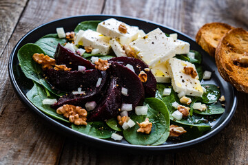  Beetroot salad with feta cheese on wooden background
