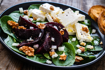  Beetroot salad with feta cheese on wooden background
