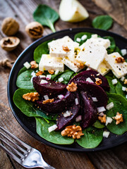  Beetroot salad with feta cheese on wooden background
