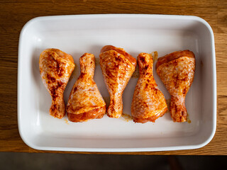 Marinated raw chicken drumsticks ready to roast
