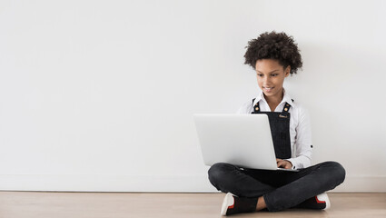 Little girl using laptop over grey wall background, child working online on computer at home panoramic banner, children lifestyle, distance education, studying at home, technology, people concept