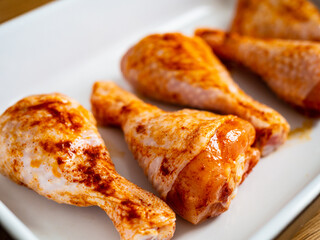 Marinated raw chicken drumsticks ready to roast
