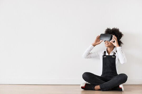Beautiful little girl using virtual reality headset sitting on the floor panoramic banner, VR, future, gadgets, technology concept 