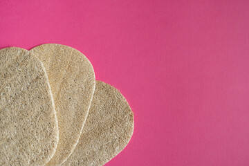 Natural loofah kitchen dish washing sponges. Eco friendly dishwashing sponge on a pink background. Biodegradable dishwashing scrub pad.