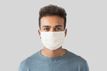 Portrait of a young man wearing protective face mask, Masked men studio portrait isolated on gray...