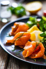 Salmon salad - smoked salmon with vegetables on wooden table