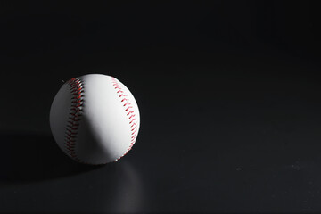 American traditional sports game. Baseball. Concept. Baseball ball and bats on a black table.