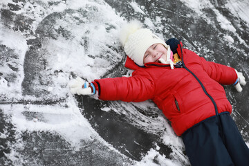Children play outside in the winter. Snow games on street.