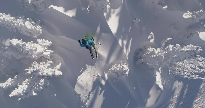 AAerial: Ski touring man crossing over the camera view. Ski touring in the mountains in winter season fresh snow. guy of ski touring on skin uphill in a line. Powder day. ski vacation travel concept